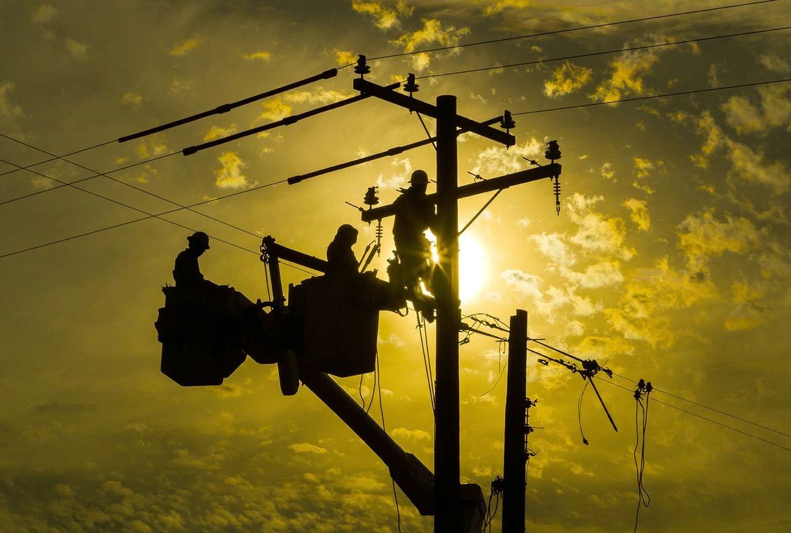 A group of men working on power lines.