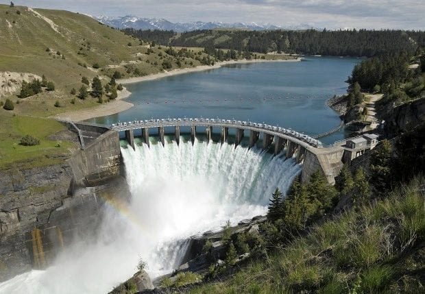 A large dam with water coming out of it.
