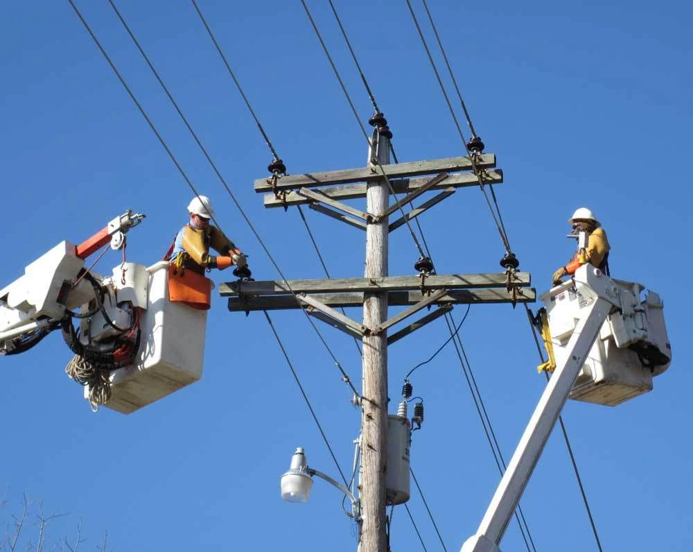 Two men working on a power line.